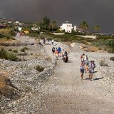 Des personnes quittent le village de Kiotari, menacé par les incendies sur l'île de Rhodes.